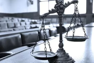 A scale of justice on a courtroom table.