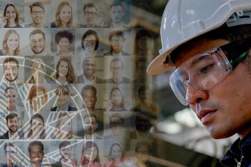 A man in hard hat and goggles looking at faces of people.