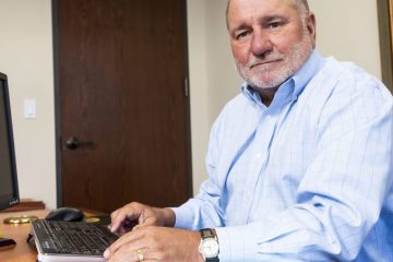 A man sitting at his desk with a laptop.