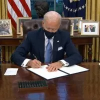 A man sitting at a desk with papers in front of him.