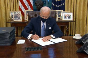 A man sitting at a desk with papers in front of him.