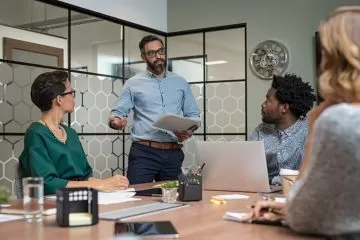 Business team meeting with presenter and laptop