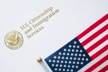 A close up of an american flag on top of a white paper.