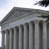 A close up of the front of a building with columns.