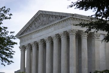 A close up of the front of a building with columns.