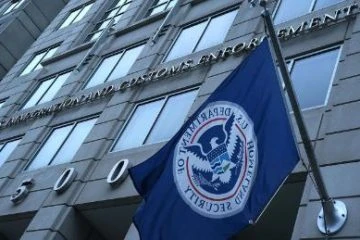A flag flying in front of the us customs office.