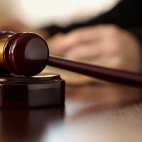 A judge 's gavel on top of a wooden table.