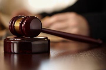 A judge 's gavel on top of a wooden table.