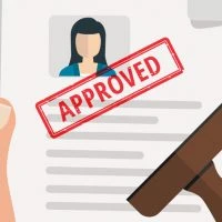 A person is sitting in front of an approved document.