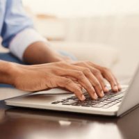 A person typing on a laptop computer.