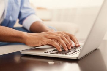 A person typing on a laptop computer.