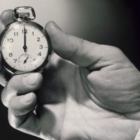 A person holding an old pocket watch in their hand.