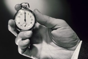 A person holding an old pocket watch in their hand.