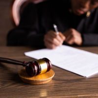 A judge 's gavel and paper on the table.