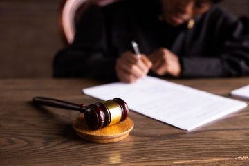 A judge 's gavel and paper on the table.