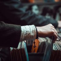 A person holding onto some records in their hand.