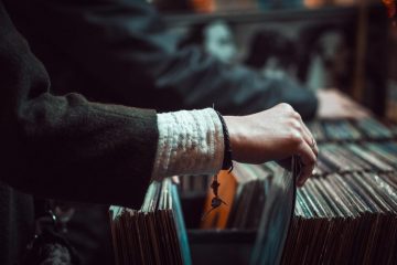A person holding onto some records in their hand.