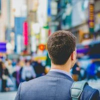 A man in a suit and tie standing on the street.