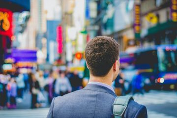 A man in a suit and tie standing on the street.