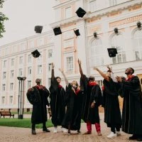 A group of people in graduation robes throwing their hats.