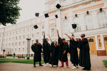 A group of people in graduation robes throwing their hats.