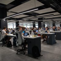 A group of people sitting at tables in an office.