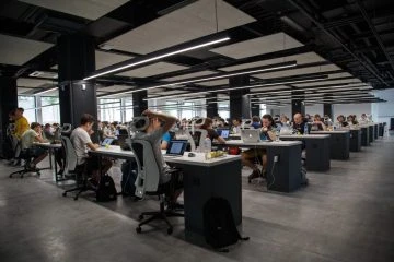 A group of people sitting at tables in an office.