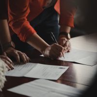 A group of people sitting at a table with papers.