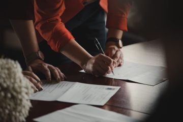 A group of people sitting at a table with papers.